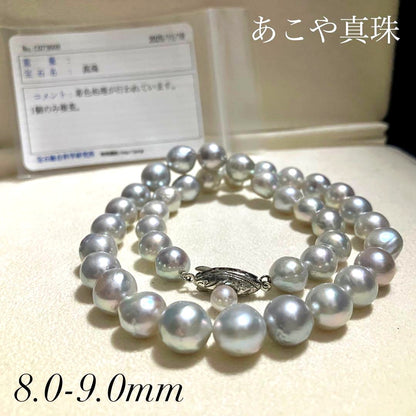 Akoya pearl necklace with 9.0mm pearls laid out showing clasp and identification book