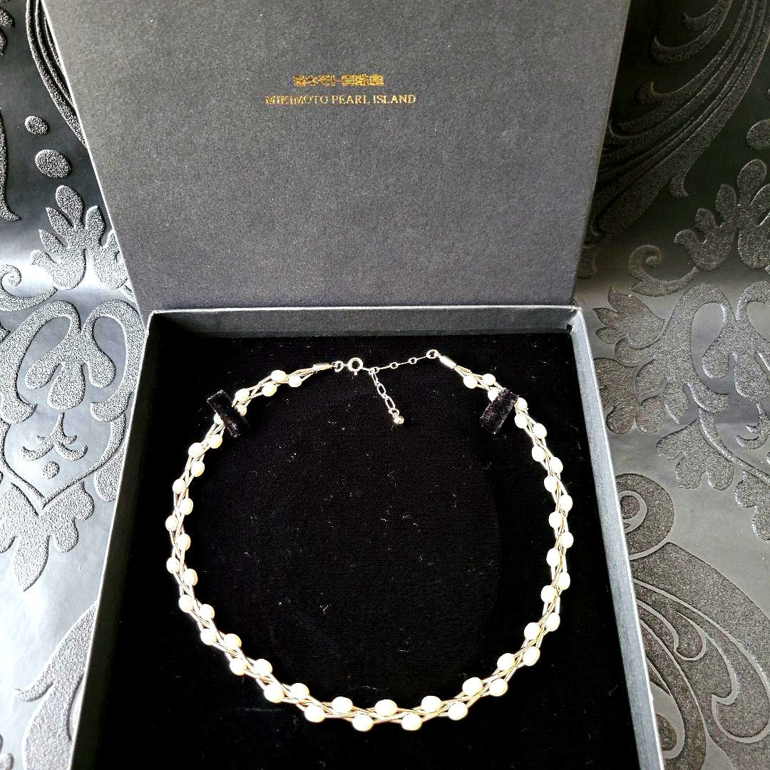 Elegant white Mikimoto Pearl Island pearl necklace with metal accents and adjustable clasp shown in dedicated box