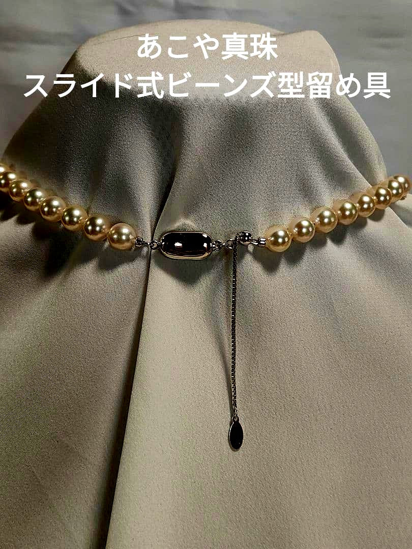 Akoya pearl necklace with white 7mm pearls and silver beans-shaped slide clasp on a plain background
