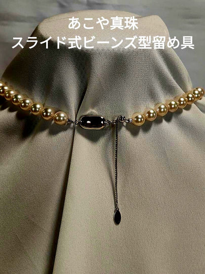 Akoya pearl necklace with white 7mm pearls and silver beans-shaped slide clasp on a plain background