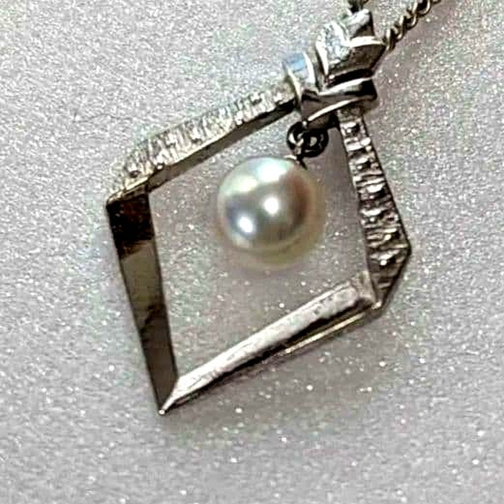 Mikimoto necklace with silver diamond-shaped pendant and glossy white pearl hanging on a 42cm silver chain