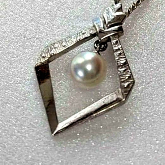 Mikimoto necklace with silver diamond-shaped pendant and glossy white pearl hanging on a 42cm silver chain