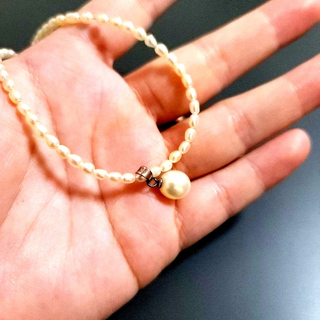Suzunoya pearl necklace with small oval Akoya pearls and 925 silver clasp on white background