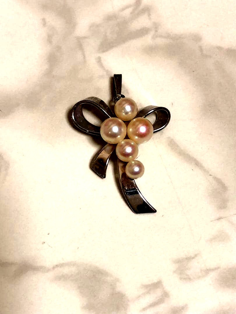 Silver ribbon-shaped pendant top adorned with five white pearls