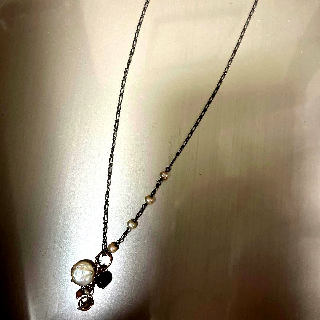Agato silver pearl necklace with chain, beads, and charm on a white background
