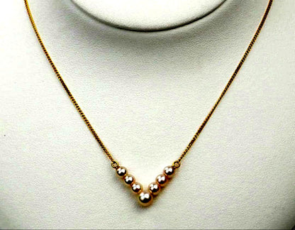 Akoya pearl necklace with V-shaped line and size-gradient pearls on a white background