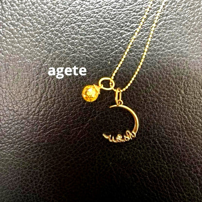 Agete gold pendant top with crescent moon and star motif on a white background