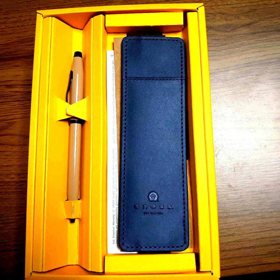 Cross navy leather pen alongside navy genuine leather case set on white background