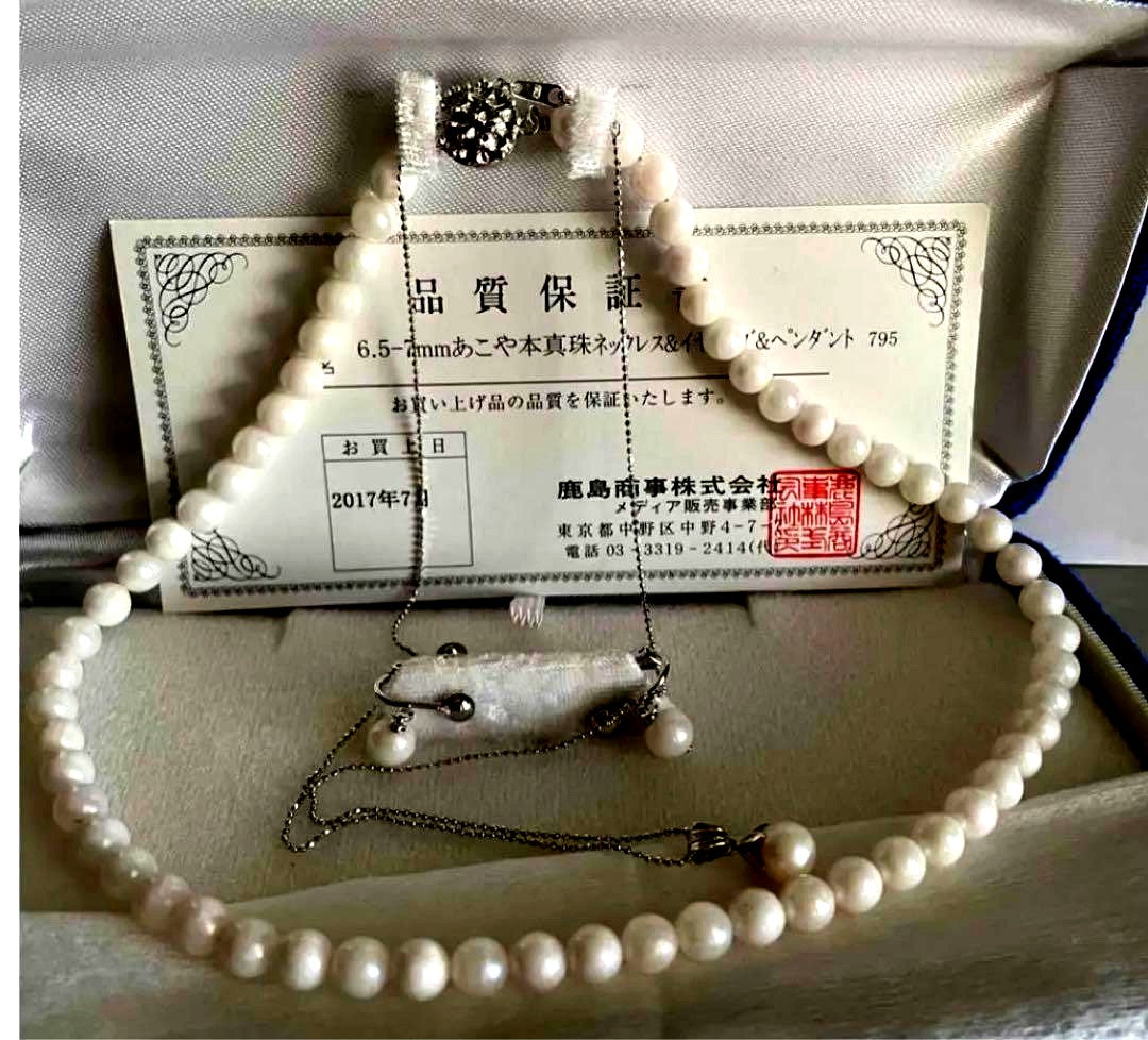 Akoya pearl necklace, earrings, and pendant set with 7mm pearls and silver clasp on white background