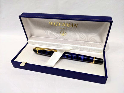 WATERMAN Philéas fountain pen with blue marble finish and gold trim displayed next to its dedicated case