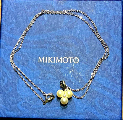 Mikimoto pearl necklace with a pendant featuring three pearls in a row, displayed in a dedicated box