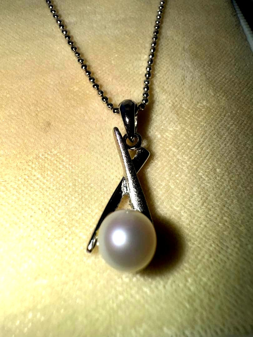 Tasaki silver necklace with a pearl pendant and lobster clasp displayed with a dedicated case