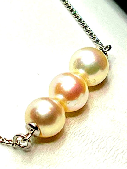 Plain Akoya pearl necklace with three 7mm round pearls on a 66cm silver chain featuring natural pink green tones