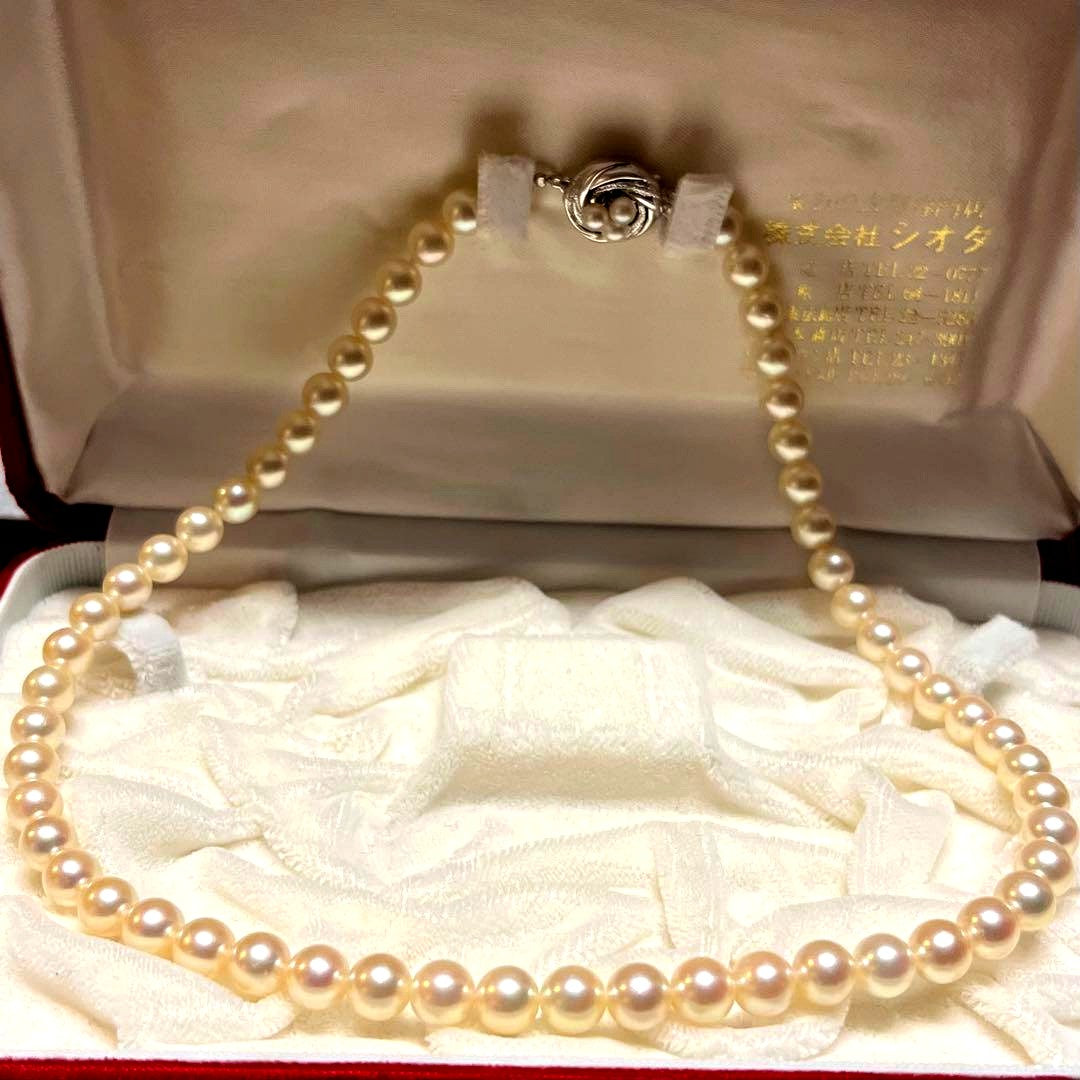 Akoya pearl necklace with 7mm pearls, silver clasp, 43cm length, and three baby pearls on a white background