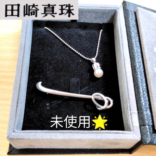 Tasaki silver necklace with 7.5mm pearl and matching brooch on white background