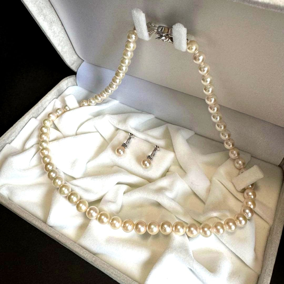 Akoya pearl necklace and earring set with white pearls and silver fittings displayed with black box