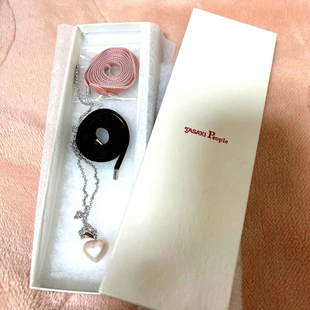 Tasaki Pearl Heart Necklace with pearl pendant and pink and black velvet ribbon set on white background