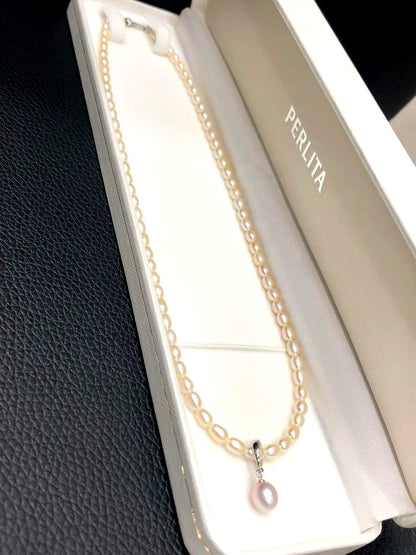 PERLITA Mikimoto pearl necklace featuring a pink pearl on a white pearl strand with dedicated case and outer box