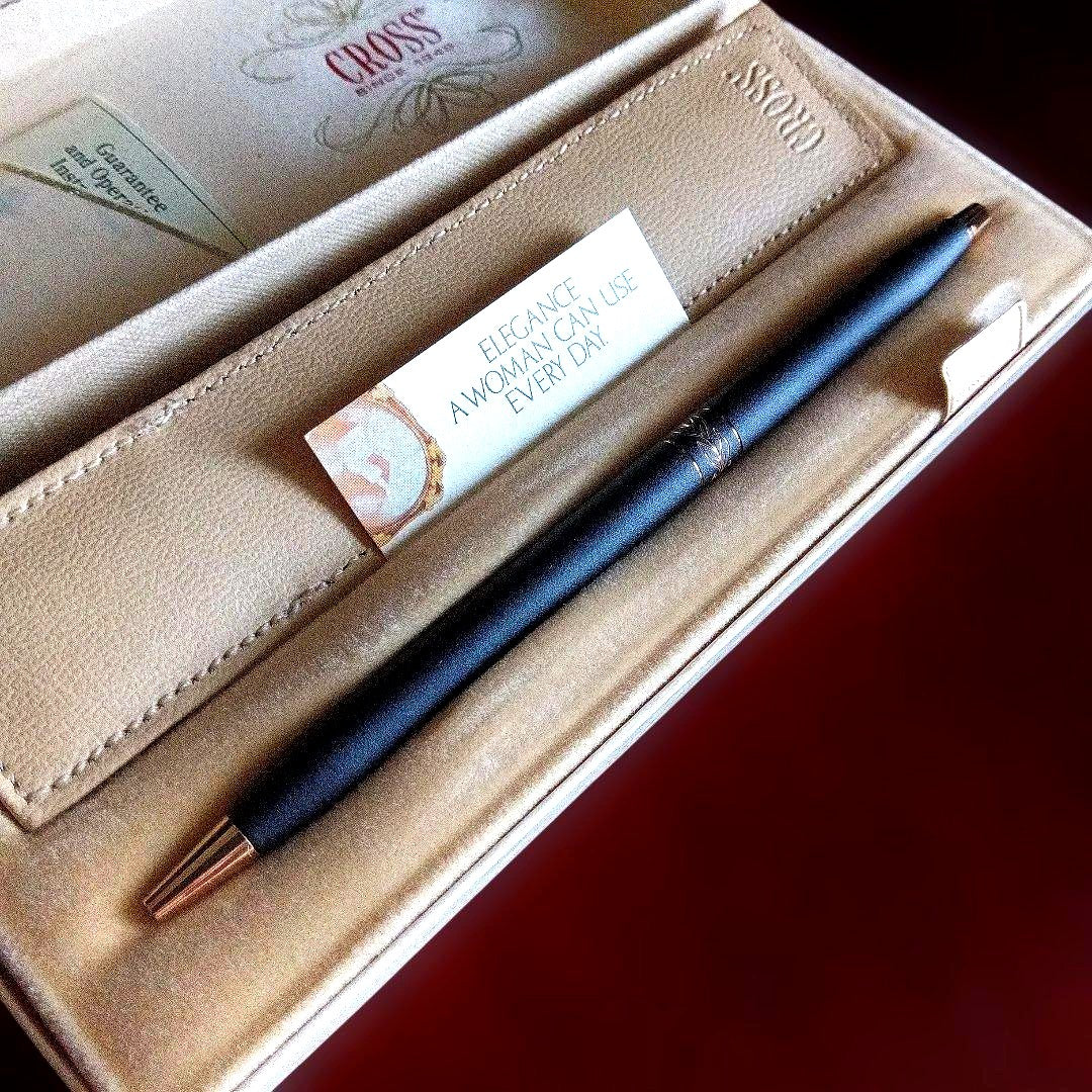 Matte black twist-style clipless women's pen with leather case on white background