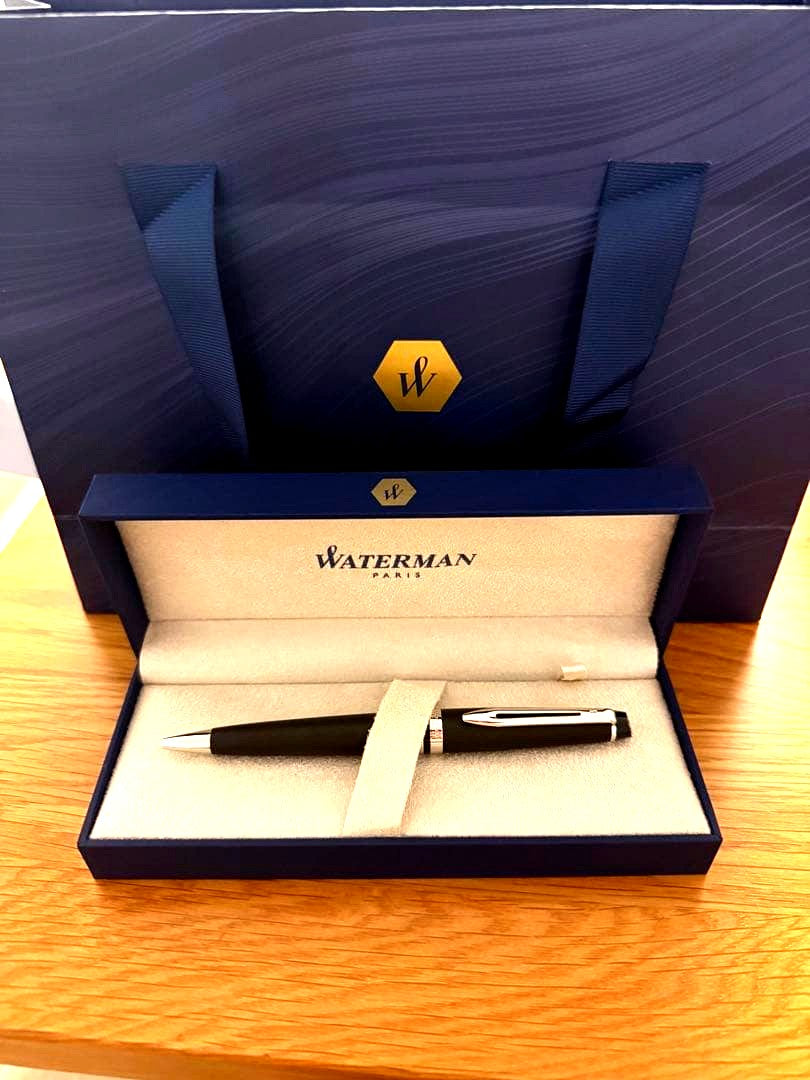 Waterman Expert Essential Matte Black CT ballpoint pen with matte finish and silver trim, shown with included paper bag