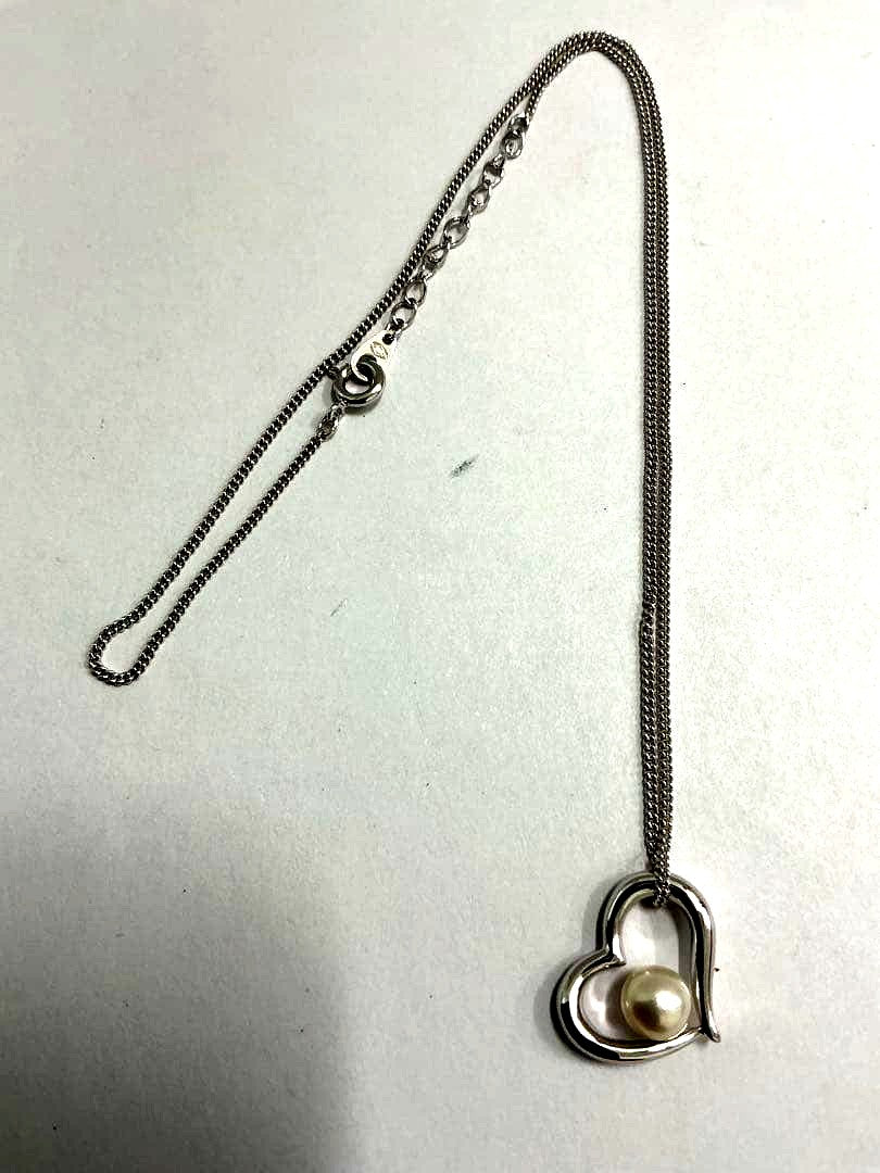 Silver color necklace featuring a heart motif decorated with a pearl and a hook clasp