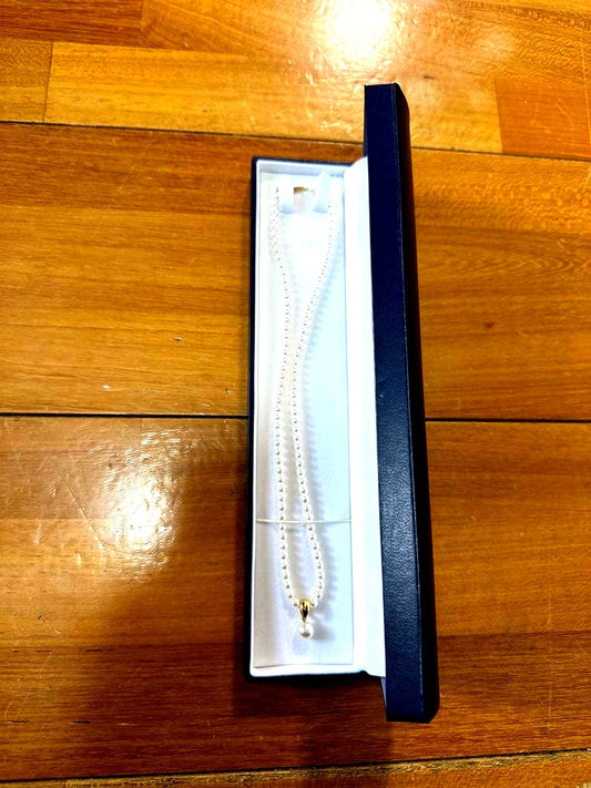Tasaki K18 gold pearl necklace with small pearls and single larger pearl at end, 42cm length