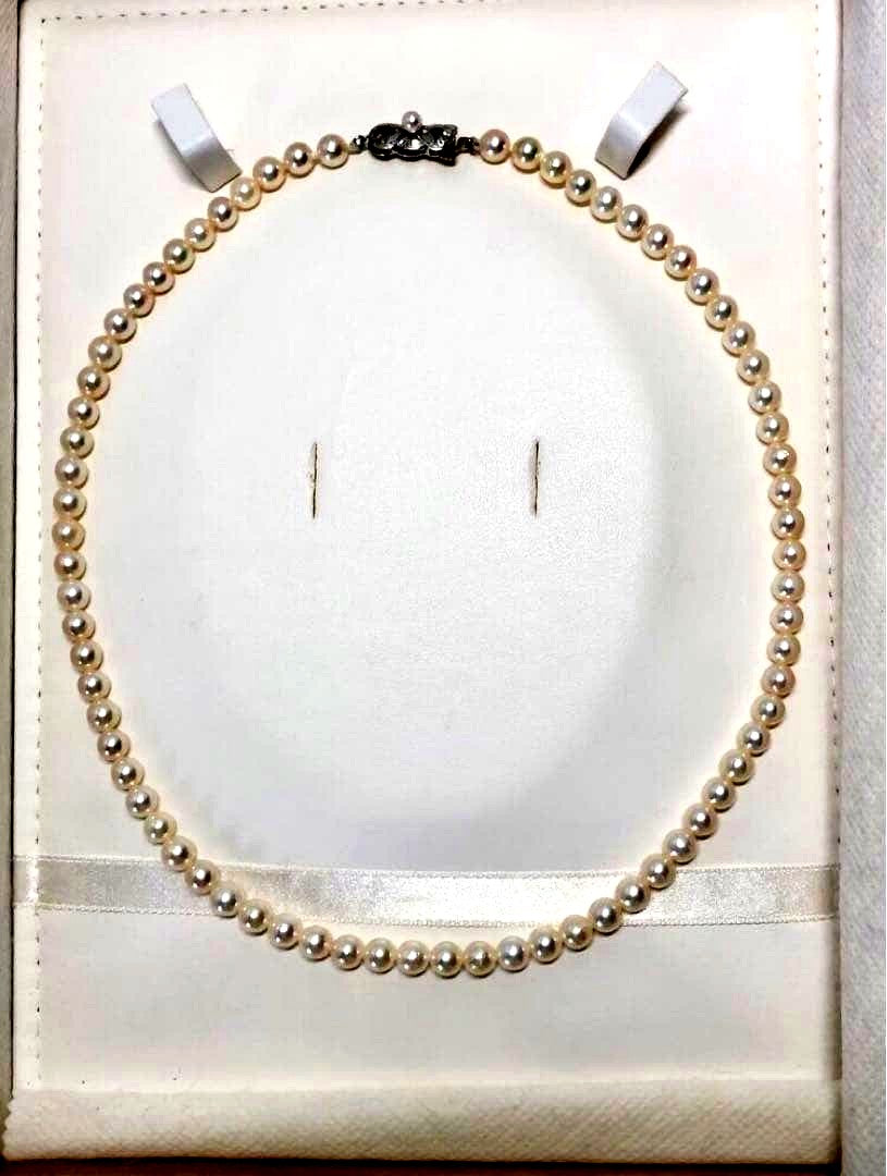 Akoya pearl necklace with round white pearls 5.5-6.0mm and silver clasp on a white background