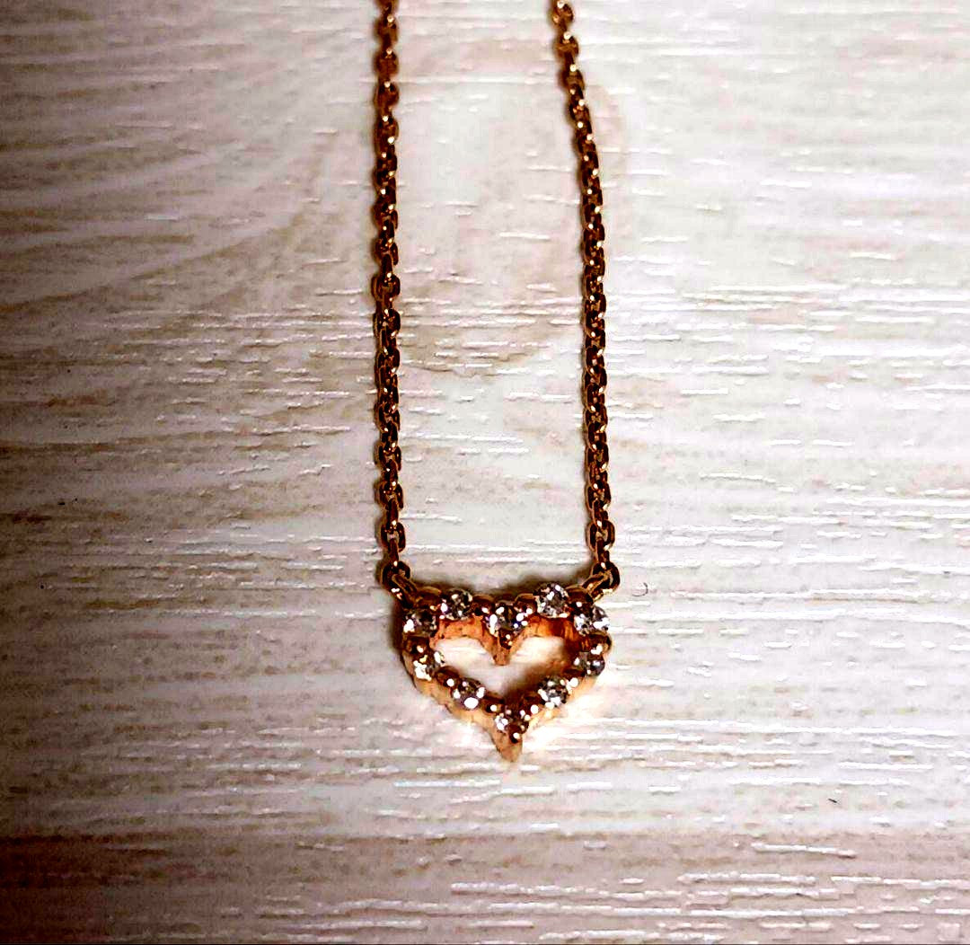 Close-up of pink gold necklace featuring an open heart-shaped agate stone with small diamonds