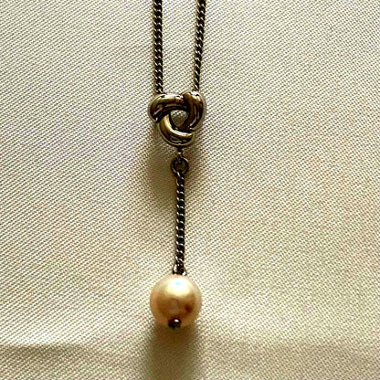 Silver Tasaki x Noevnir single pearl necklace with simple design on a white background