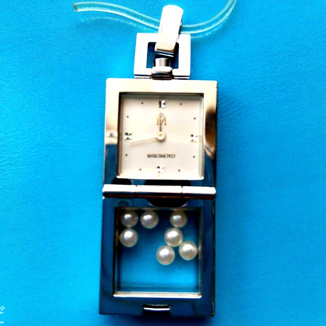 Mikimoto pendant head with decorative pearls, non-working watch, and ballpoint pen set on white background