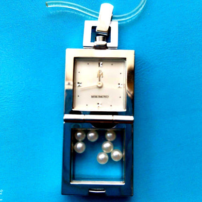 Mikimoto pendant head with decorative pearls, non-working watch, and ballpoint pen set on white background