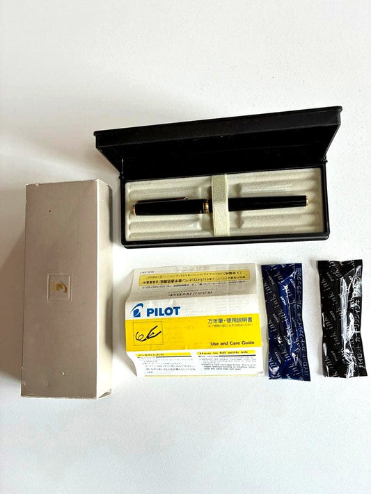 Pilot black fountain pen with medium gold-plated nib and included box, manual, and ink cartridges