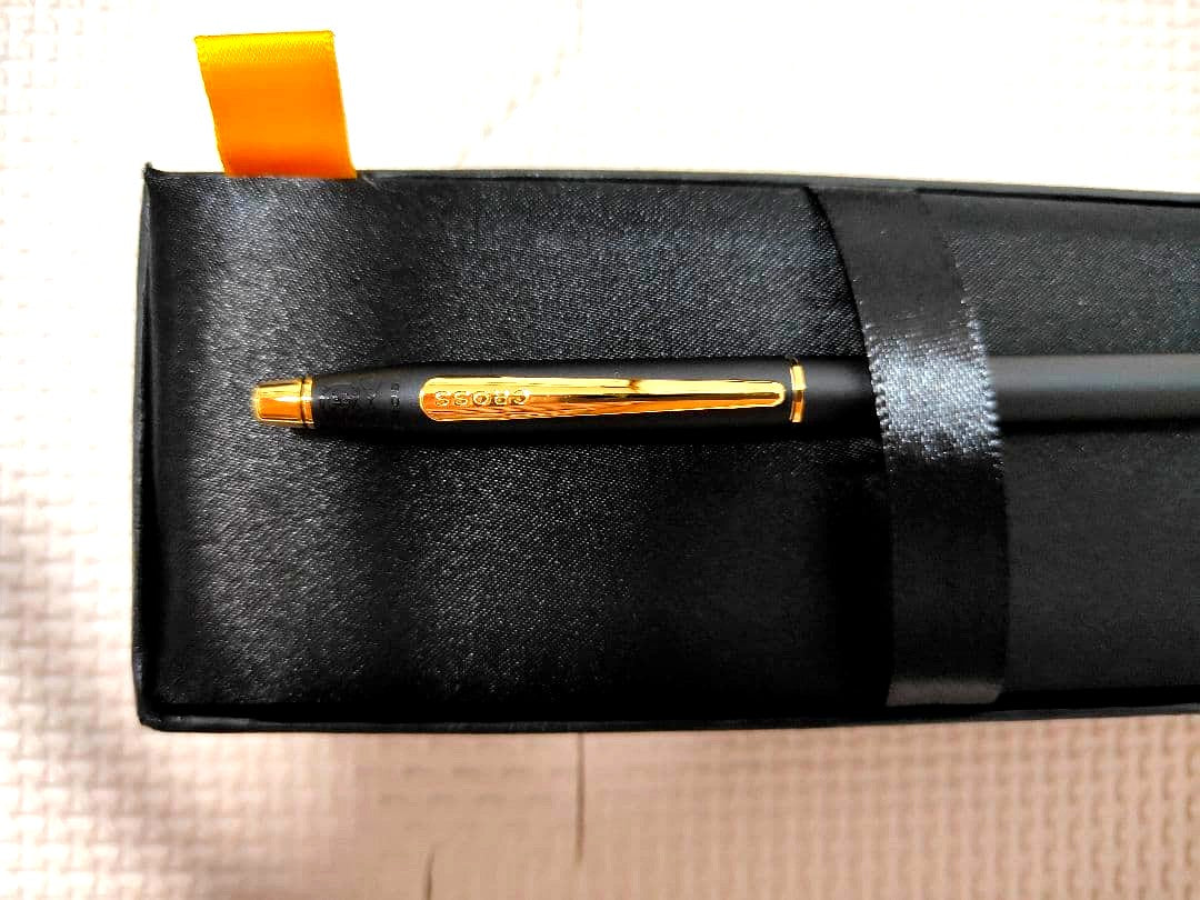 Cross black ballpoint pen with gold-colored metal fittings shown on white background