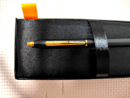 Cross black ballpoint pen with gold-colored metal fittings shown on white background