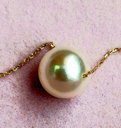 Akoya pearl pendant with 18 karat gold setting and 38cm chain on white background