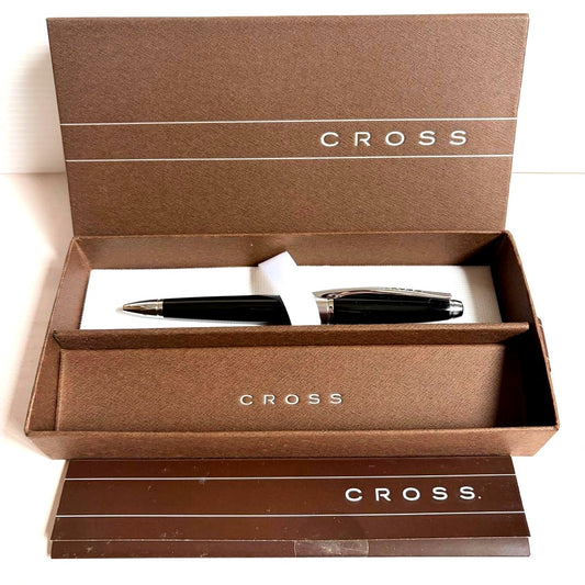 CROSS black ballpoint pen with chrome trim placed beside its dedicated metal case