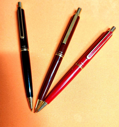 Three Pilot mechanical pencils in red and assorted colors, including used and unused items