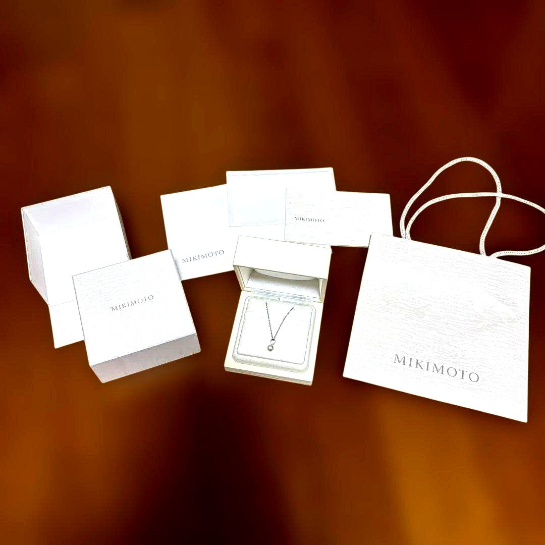 Mikimoto pearl pendant necklace with a single pearl on a delicate chain, displayed on a white background