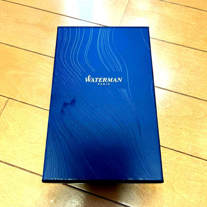 Waterman black metal ballpoint pen with accompanying brown leather case on white background