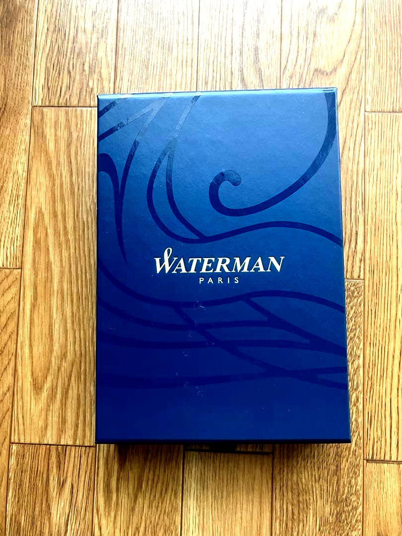 Waterman Metropolitan ballpoint pen with matte black body and gold trim lying on a white background