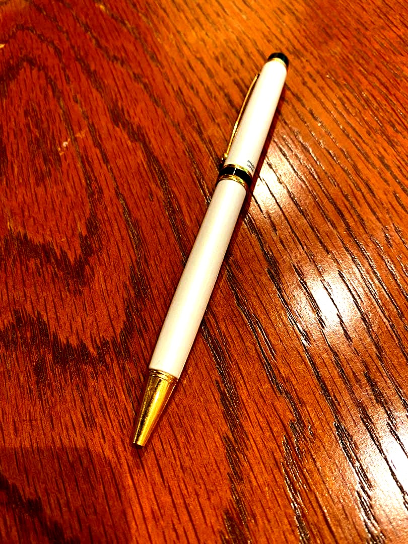 Pilot ballpoint pen with white metal body, gold trim, and blue top shown on a white background
