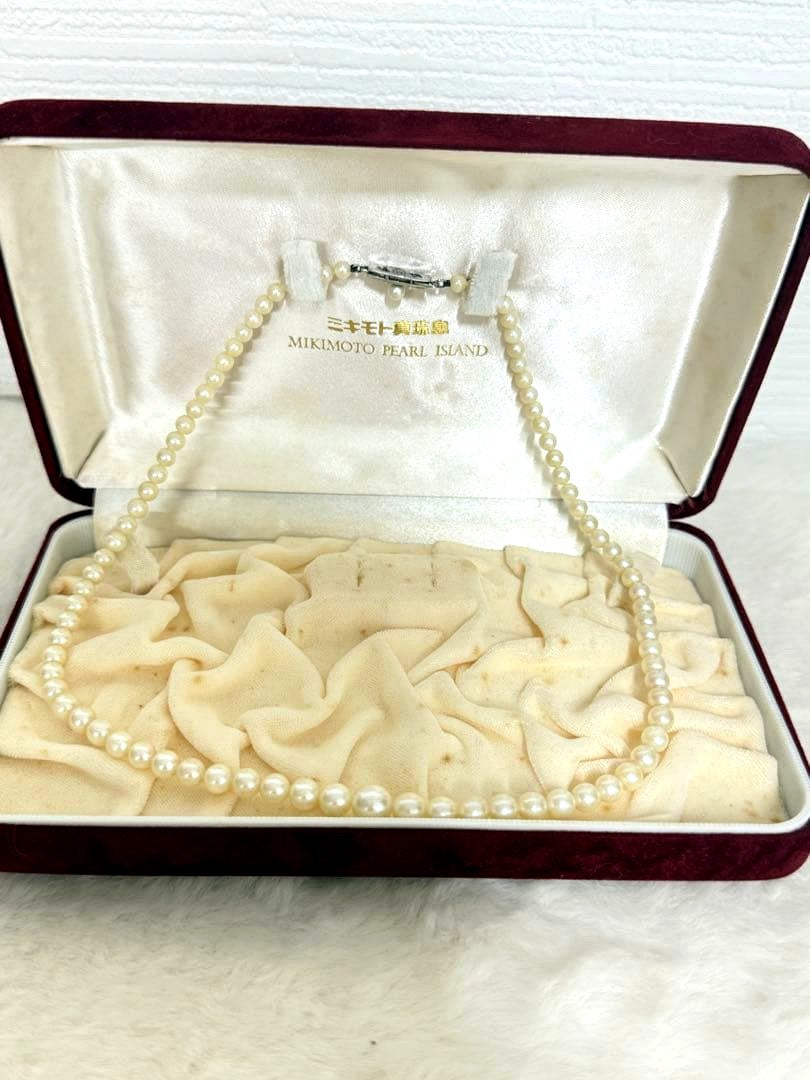 Mikimoto pearl necklace with white gold 14WG chain displayed alongside dedicated storage case