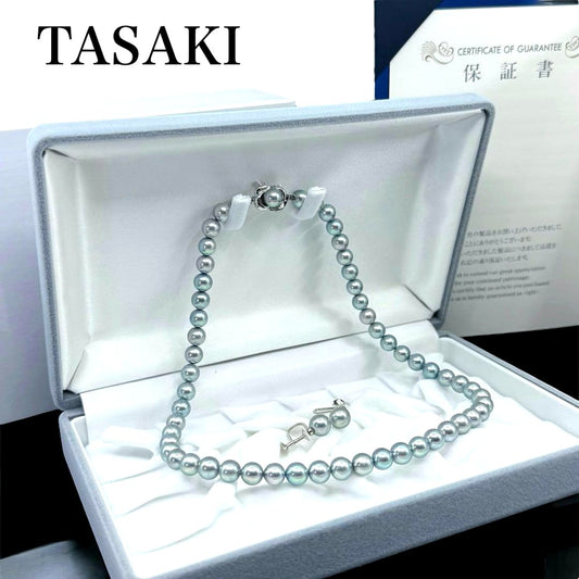 Tasaki Akoya pearl necklace and earrings set with 7mm round pearls and silver clasp on white background