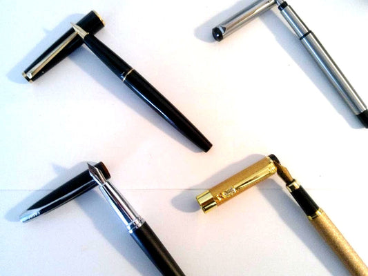 Montblanc Parker Cross Jinhao set of four pens including Montblanc model 310, displayed on white background