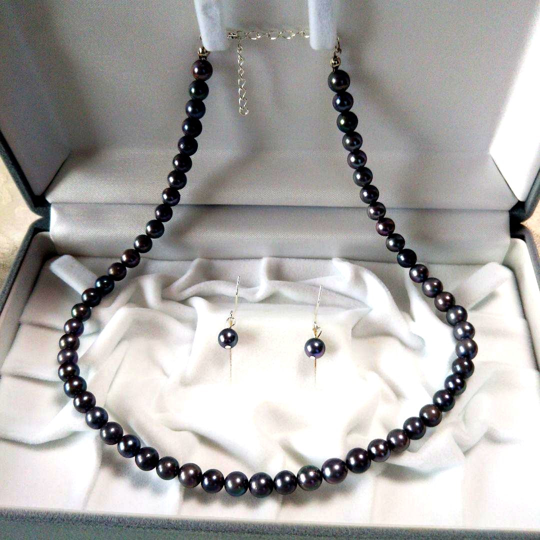 Akoya pearl necklace and matching earrings with silver clasp and findings on white background