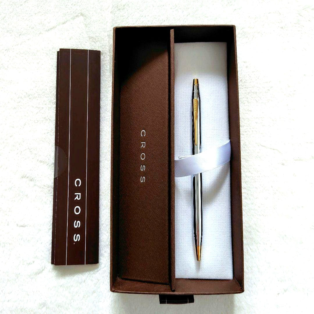Cross brand silver and gold ballpoint pen with slim design, shown with box and instruction manual