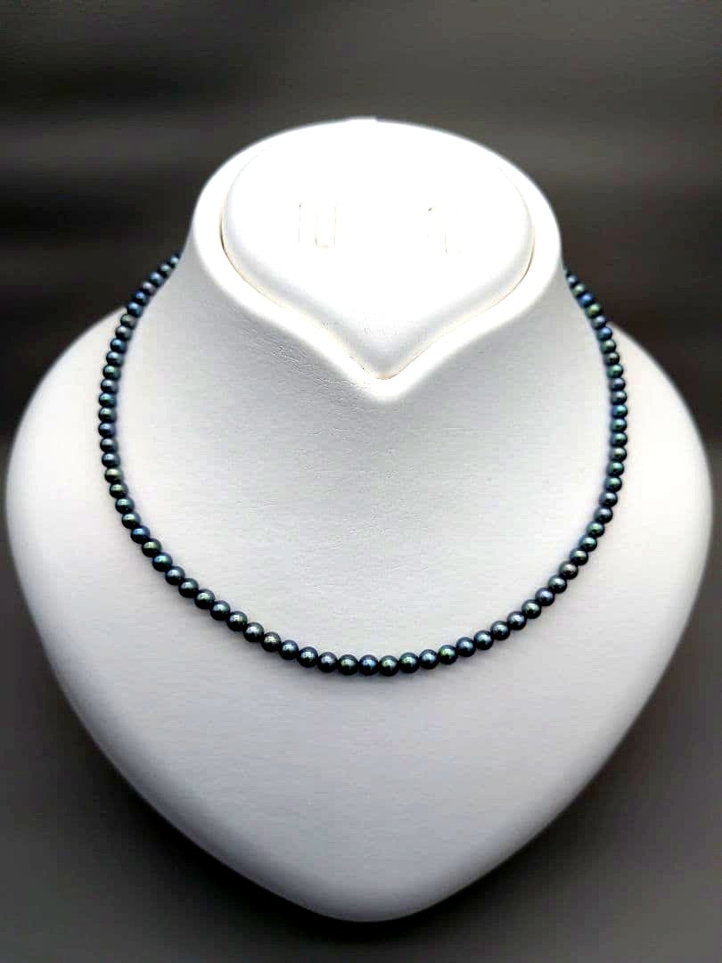 Akoya cultured pearl baby necklace with black peacock tone pearls and silver clasp on white background